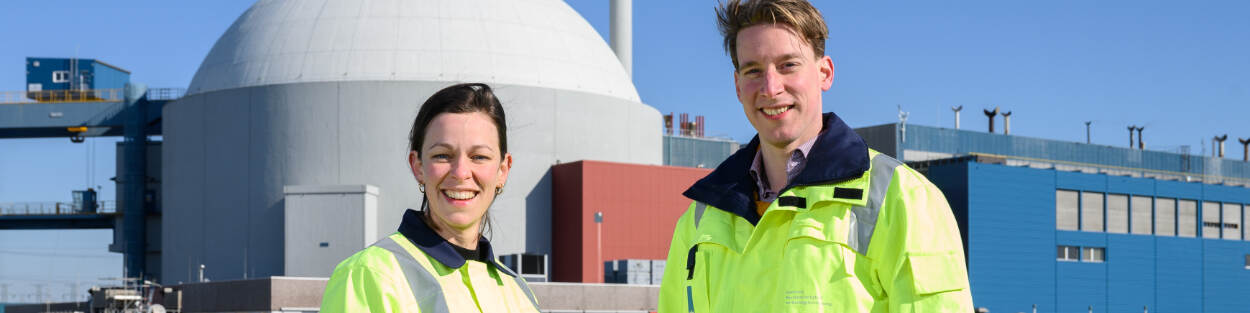 2 ANVS-inspecteurs poseren voor de koepel van kerncentrale Borssele.